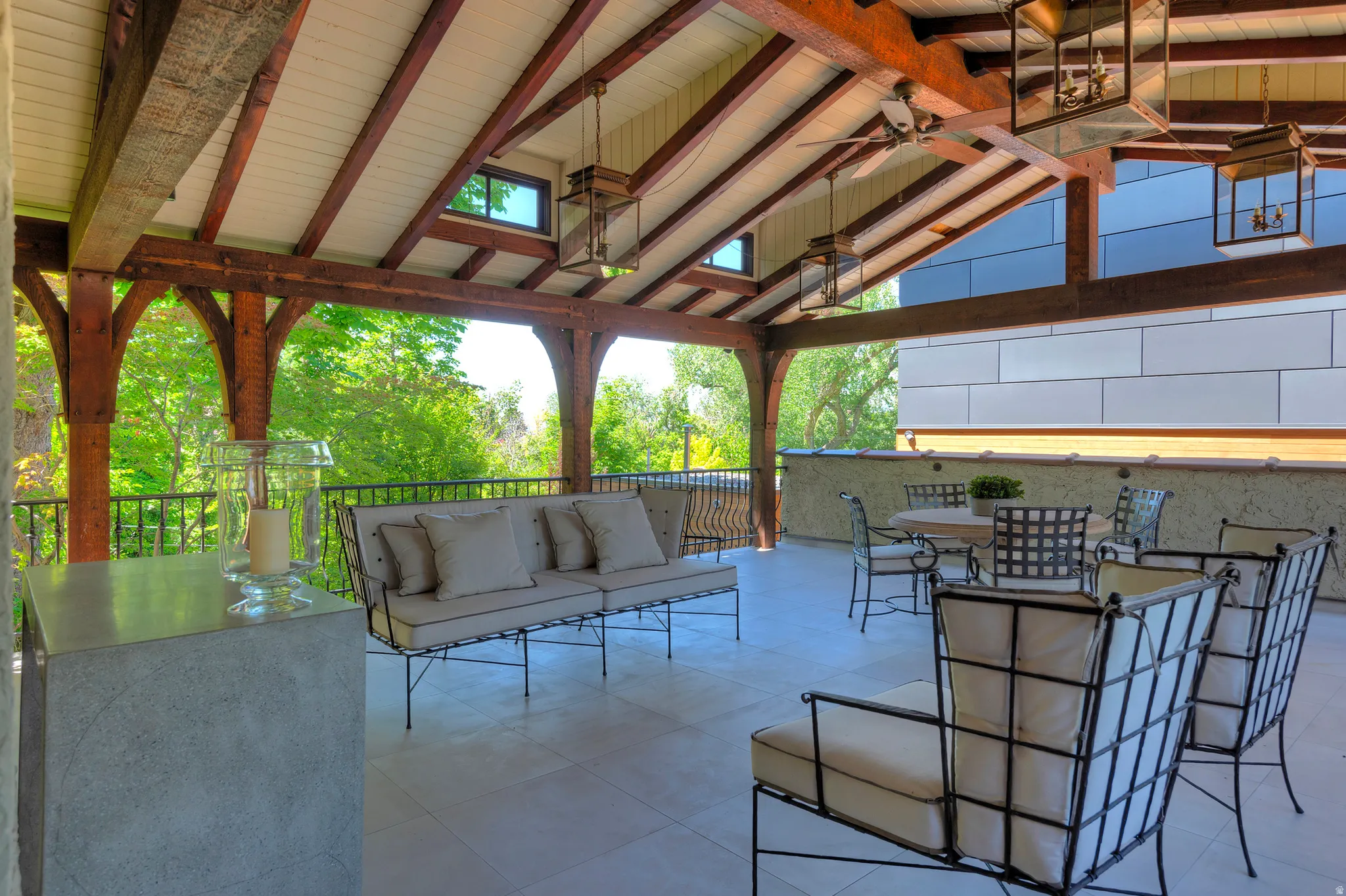 Covered outdoor living area featuring exposed wood beams and a vaulted ceiling