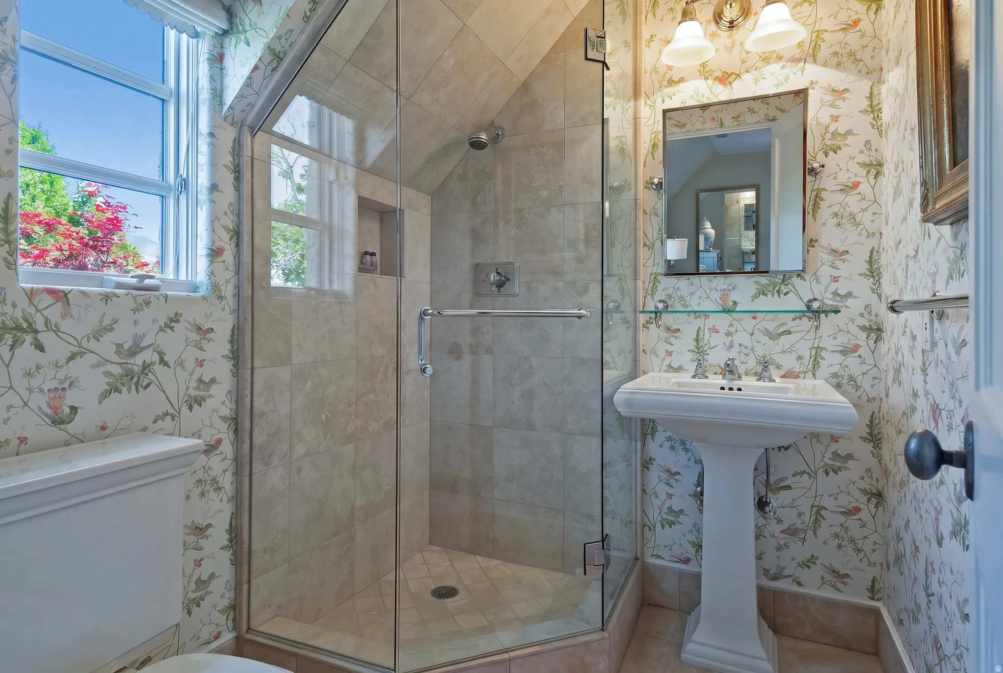 Walk-in shower with clear glass enclosure and tiled surround