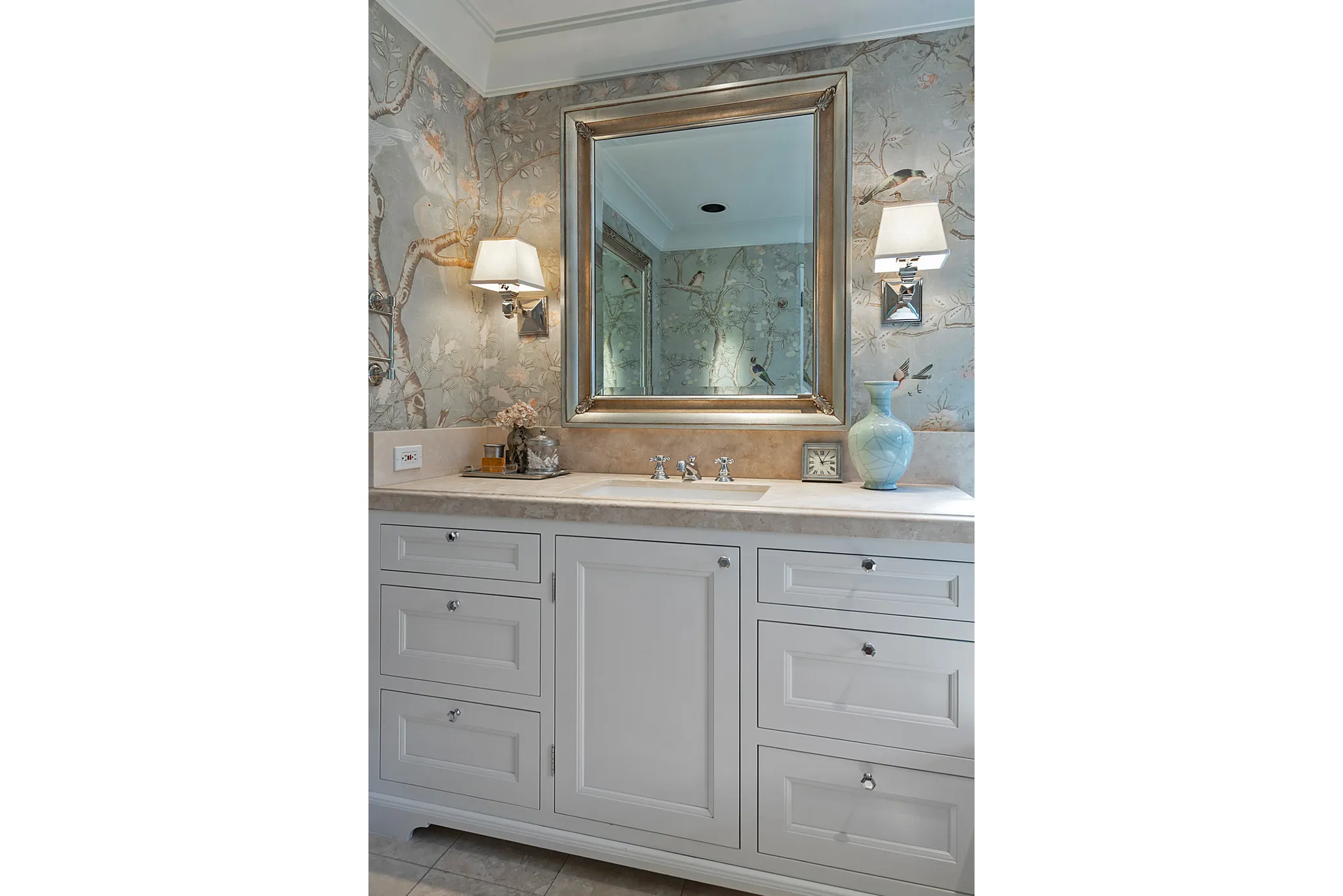 Custom vanity with integrated sink, coordinating countertop, and elegant sconce lighting