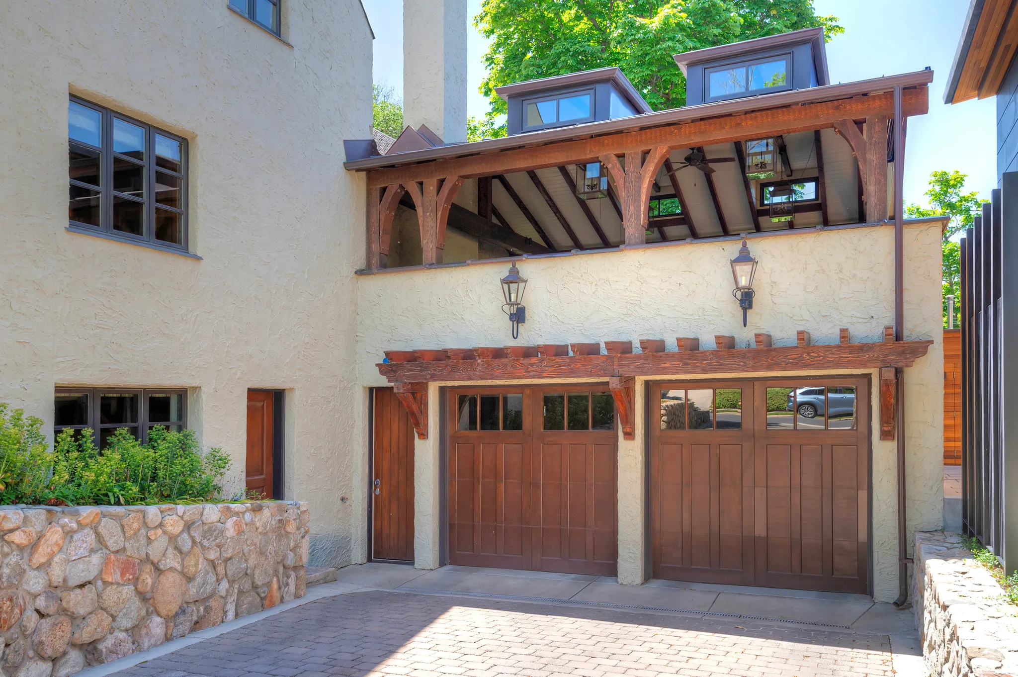 Two-car garage with rich wood-finish doors and transom windows