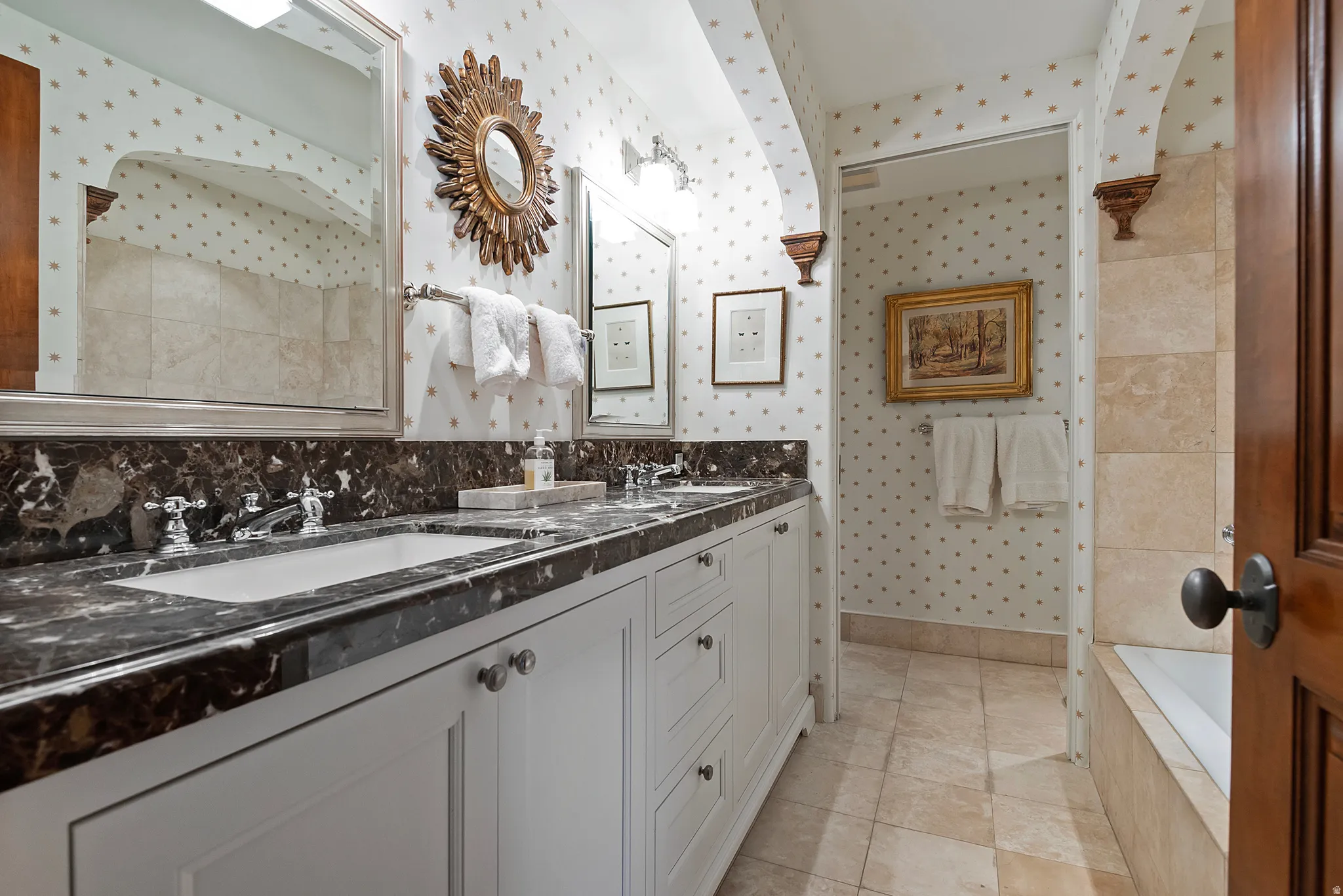 Double vanity with dark stone countertop, undermount sinks, and polished chrome fixtures