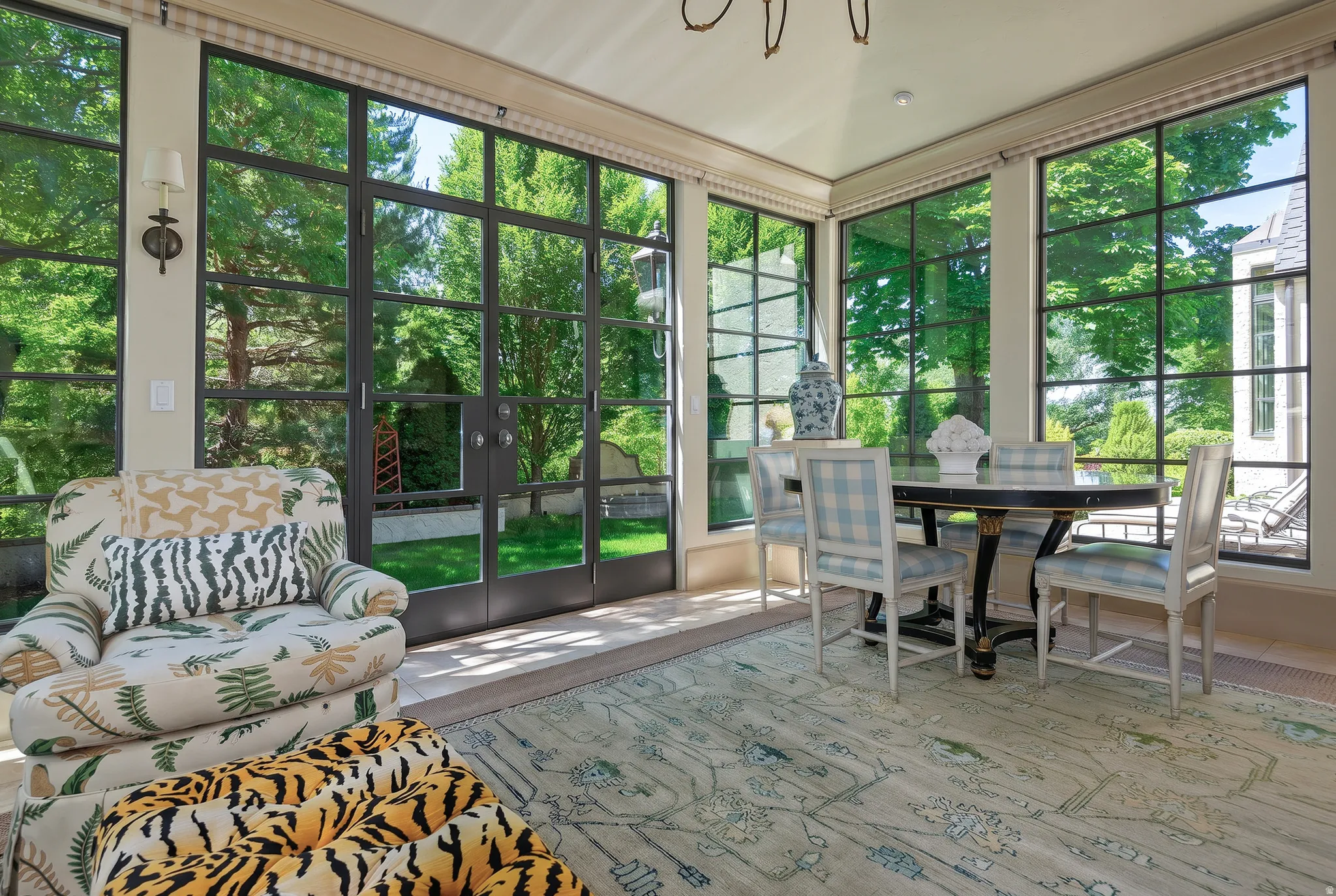 Sunroom featuring expansive gridded windows, a vaulted ceiling, and light-toned flooring