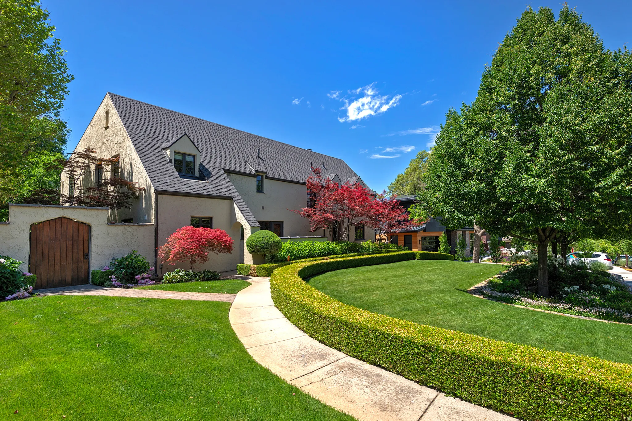 Stucco exterior with a dark shingle roof and dormer windows
