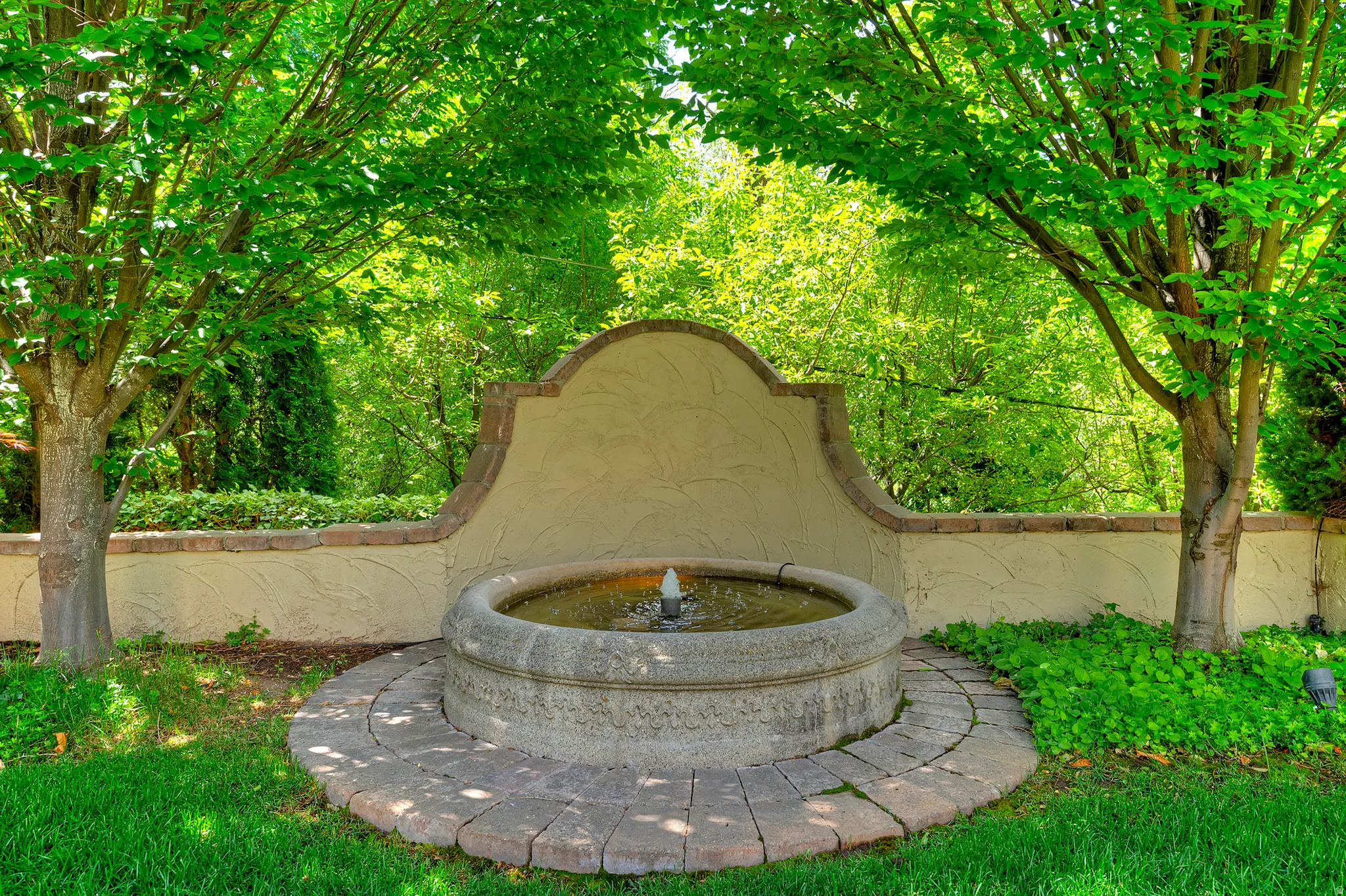 Stucco wall with decorative caps and an integrated stone fountain