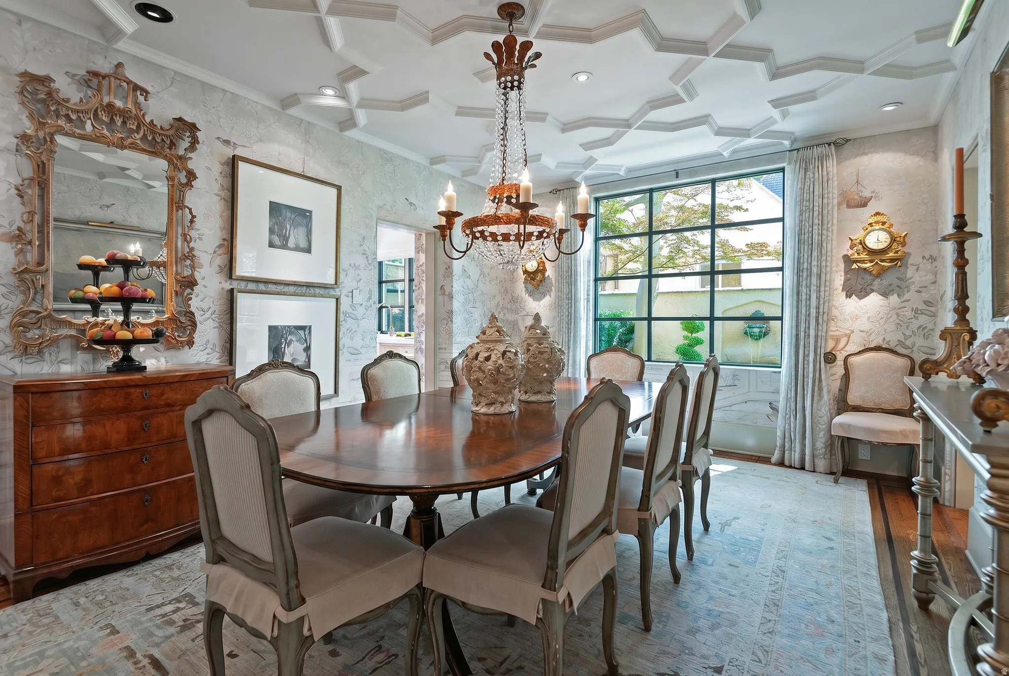 Dining area featuring a coffered ceiling, a large grid-pattern window, wallpapered walls, wood-finish flooring, and a chandelier