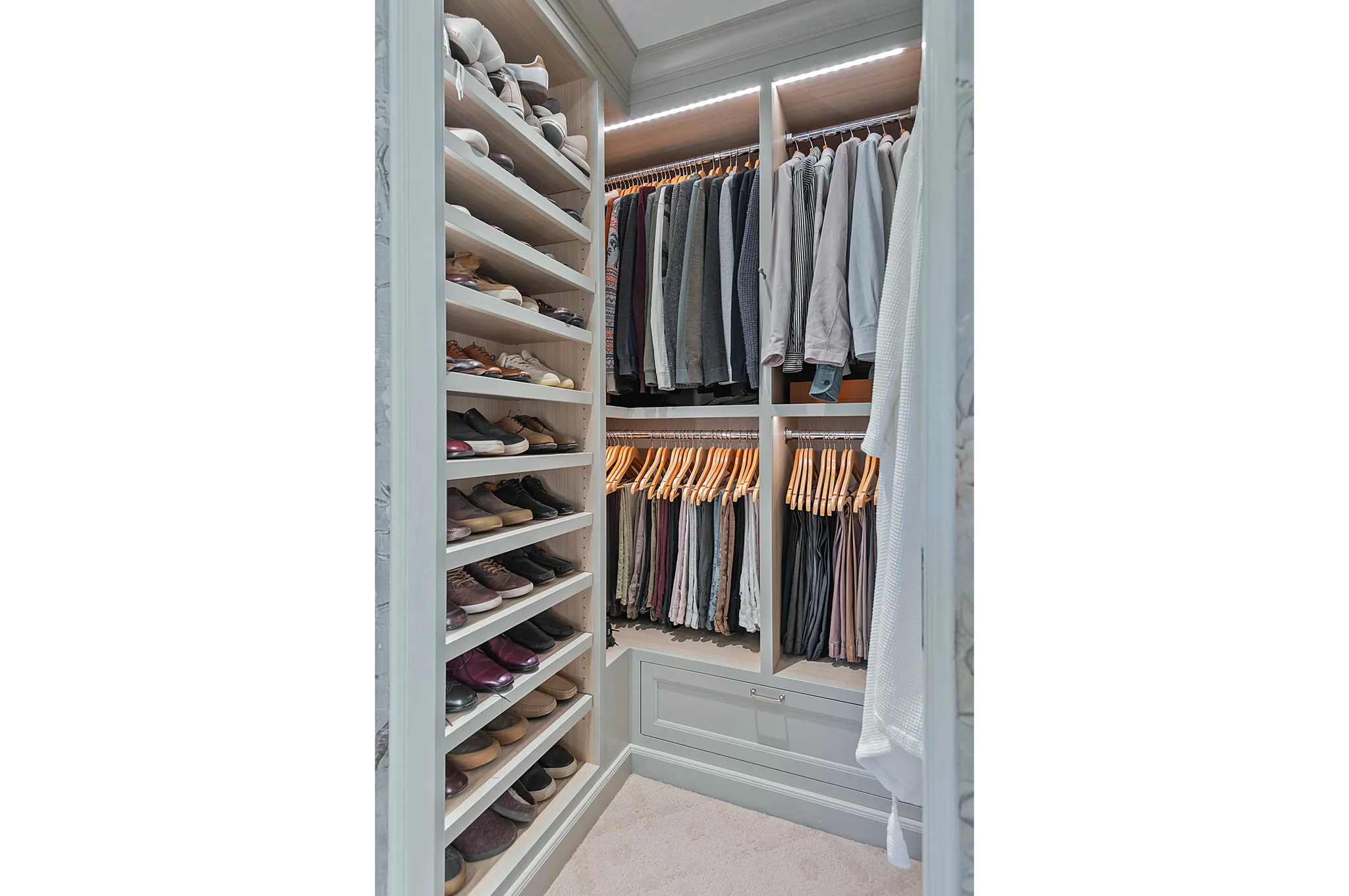 Custom closet system featuring built-in shelving, hanging rods, and integrated lighting