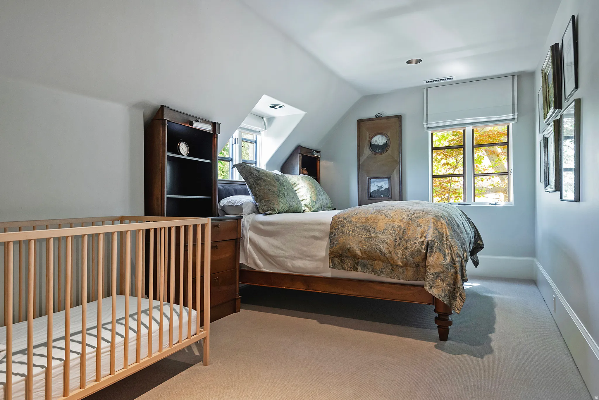 Carpeted room featuring a window with a roller shade, recessed lighting, and sloped ceilings