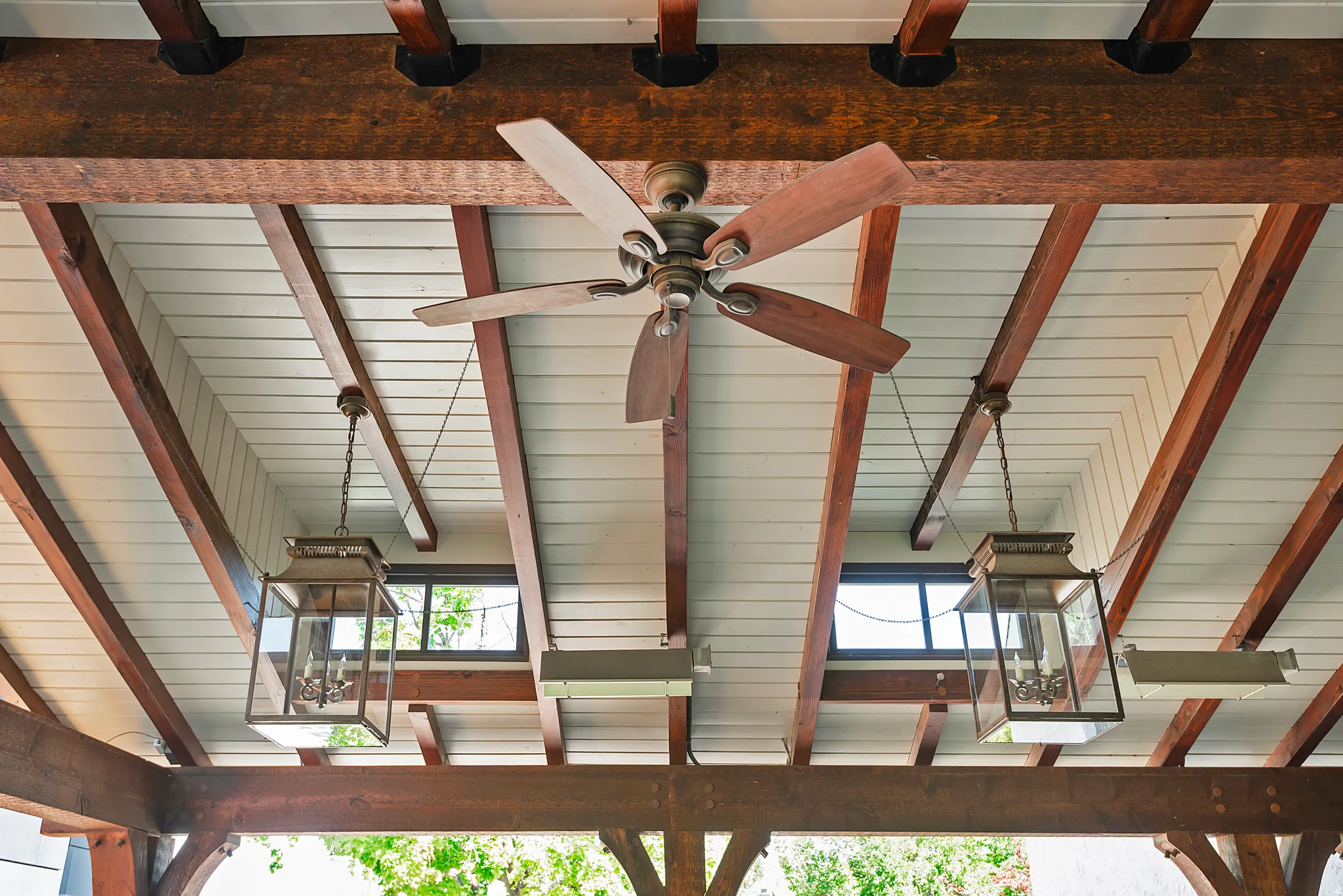 Exposed wood beams supporting a white planked ceiling