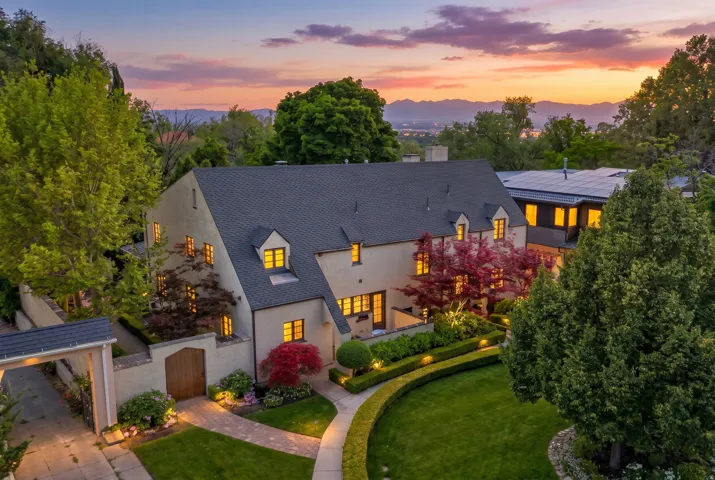 Stucco exterior residence with a dark shingled roof and multiple dormer windows