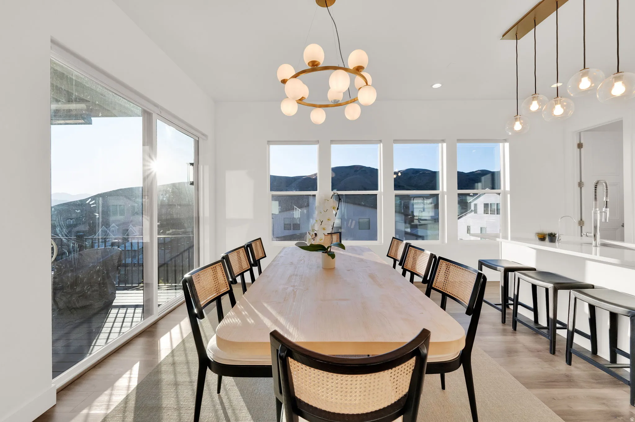 Dining area with wood-finish flooring and a contemporary circular chandelier