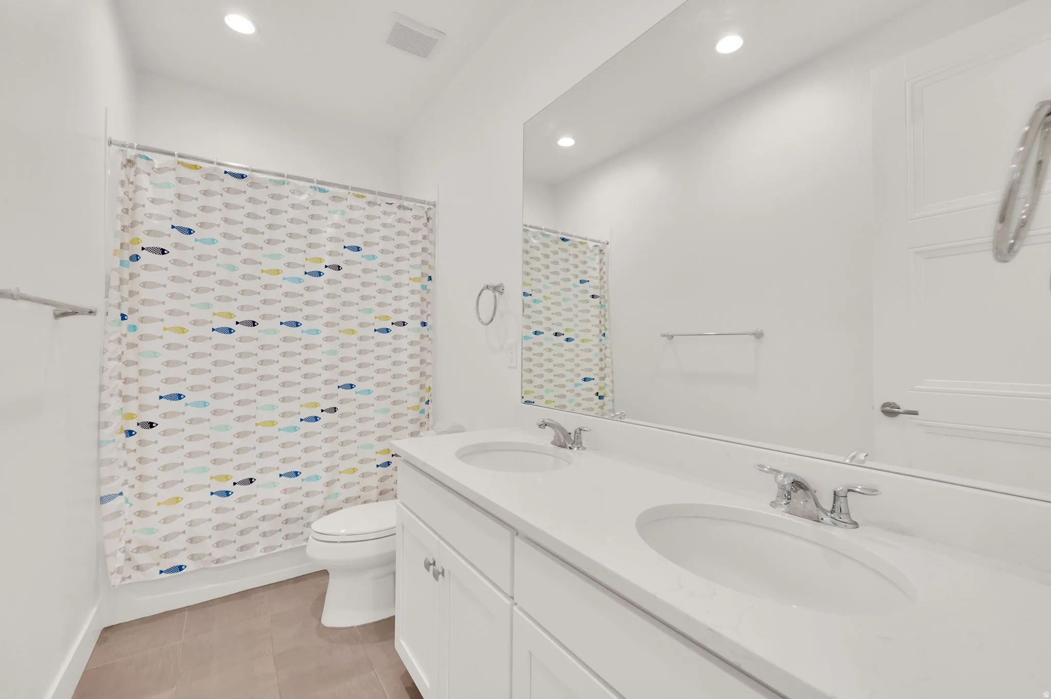 Bathroom featuring a dual vanity with undermount sinks, chrome fixtures, and a spacious countertop