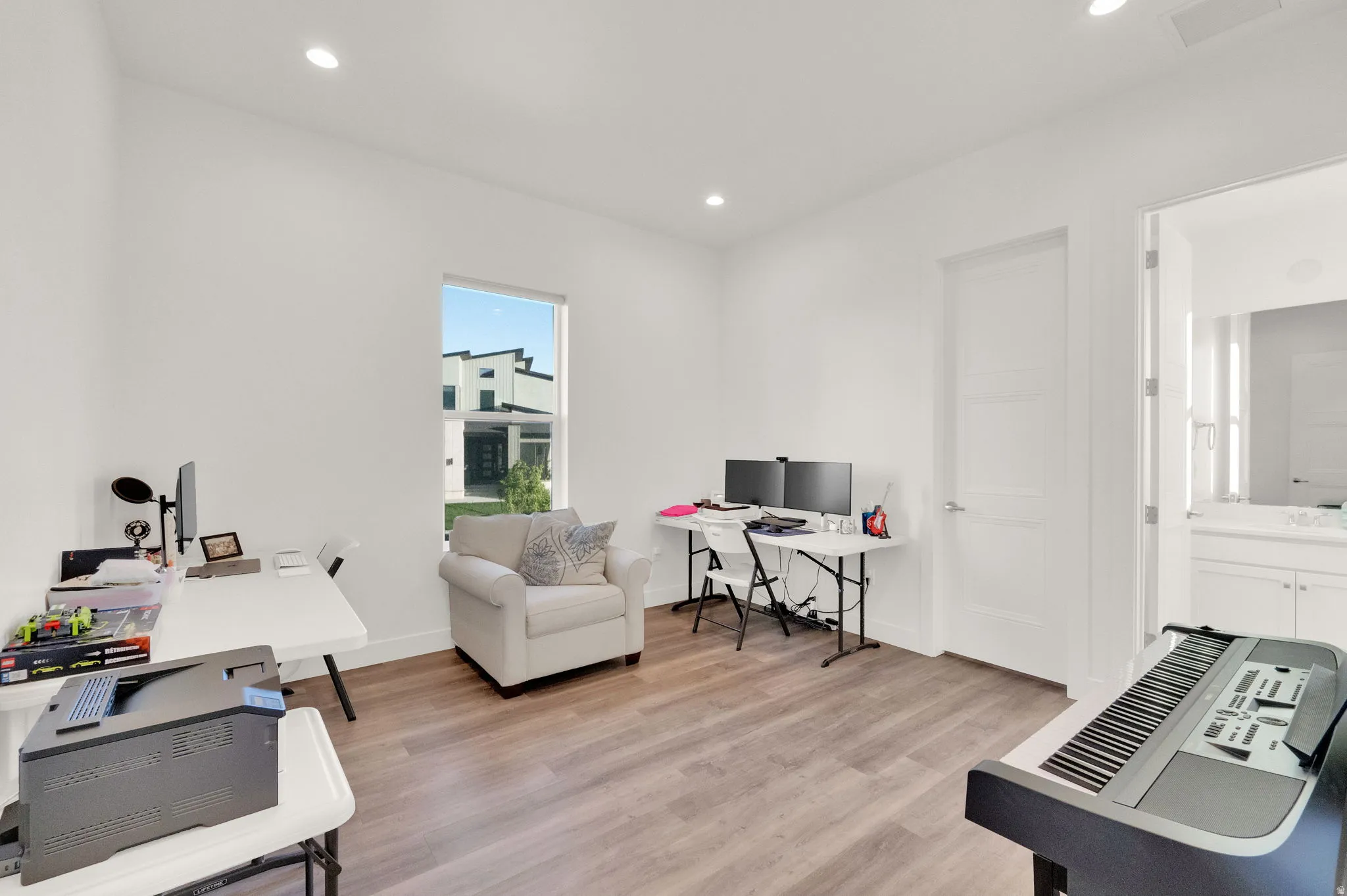 Bright room featuring wood-finish flooring, recessed lighting, and a large window