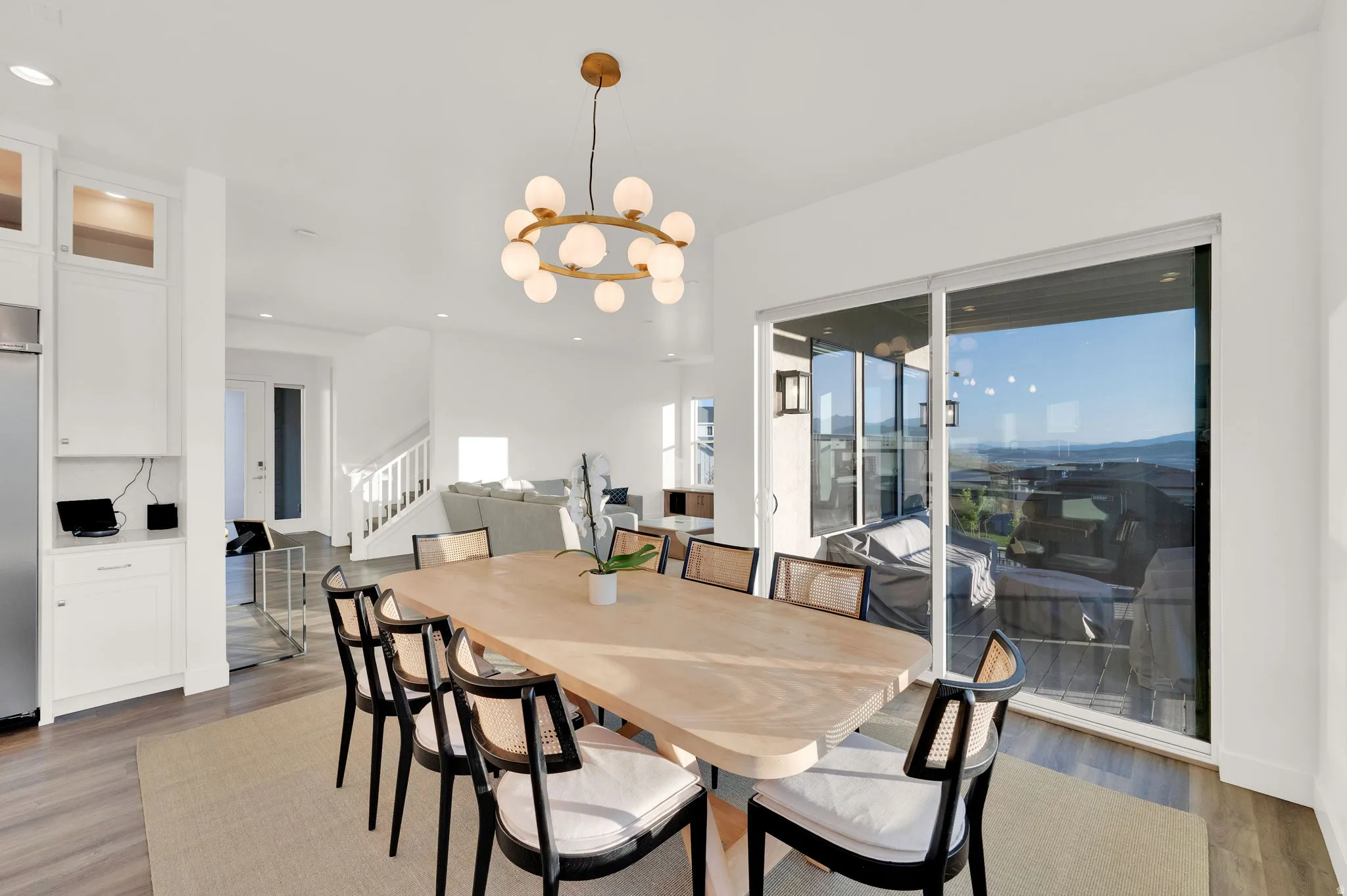 Dining area featuring a modern chandelier, light wood-finish flooring, and expansive sliding glass doors