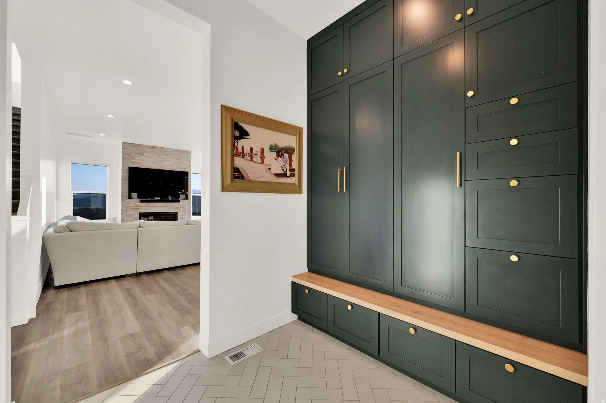 Built-in cabinetry with a wood bench and gold hardware