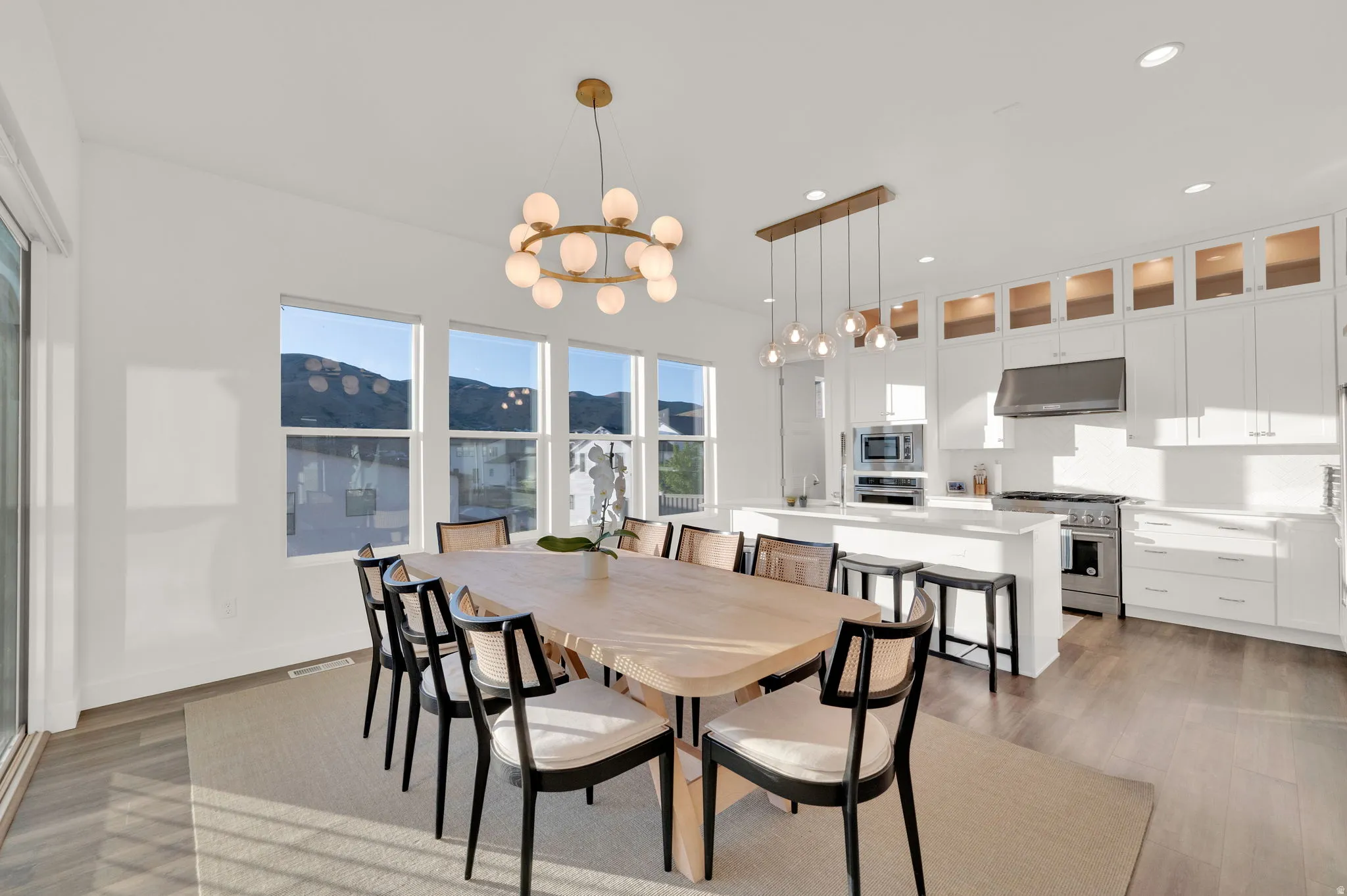 Open-concept living space featuring wood-finish flooring and multiple large windows