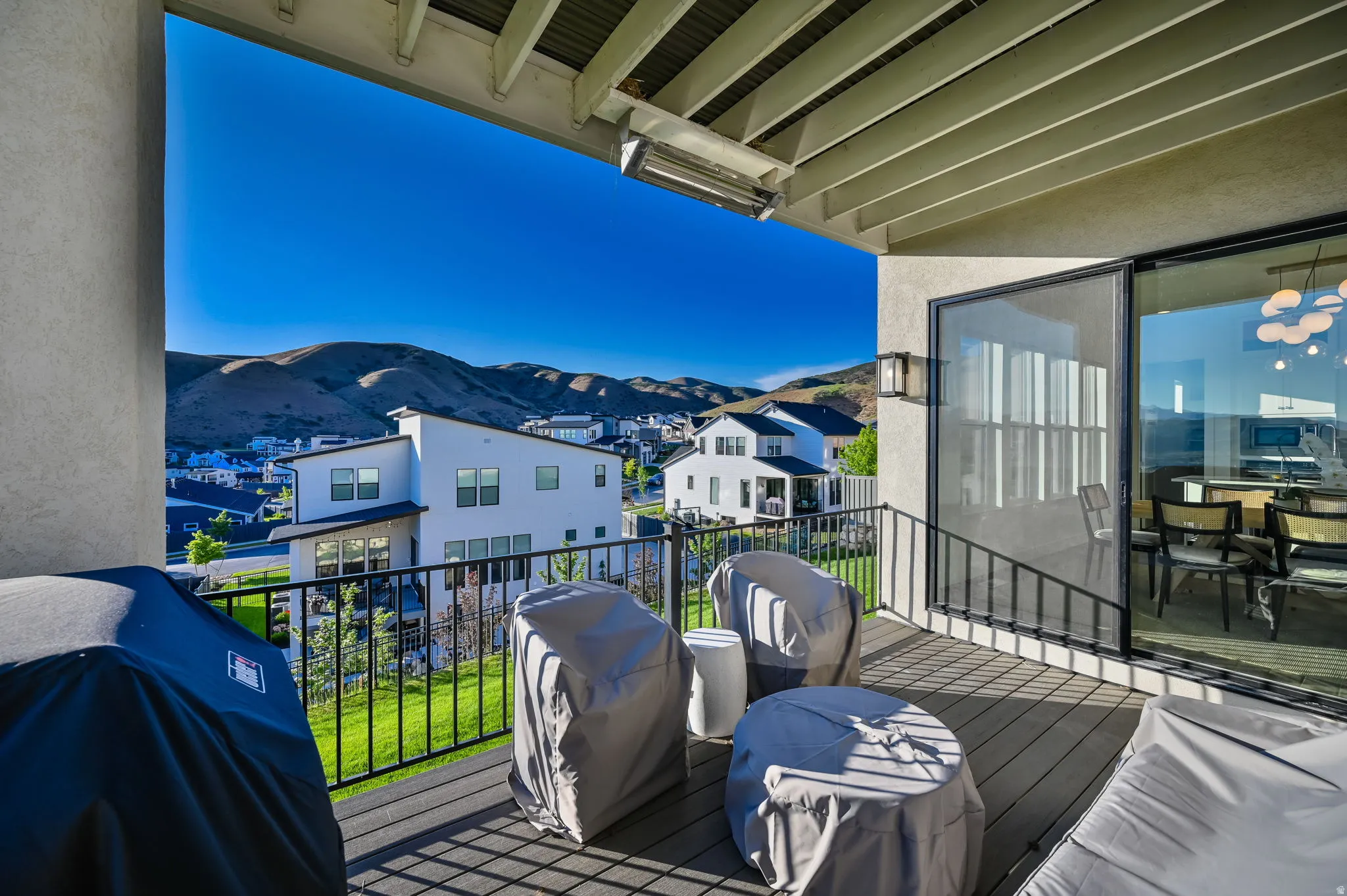 Covered balcony featuring wood-finish flooring and black metal railings