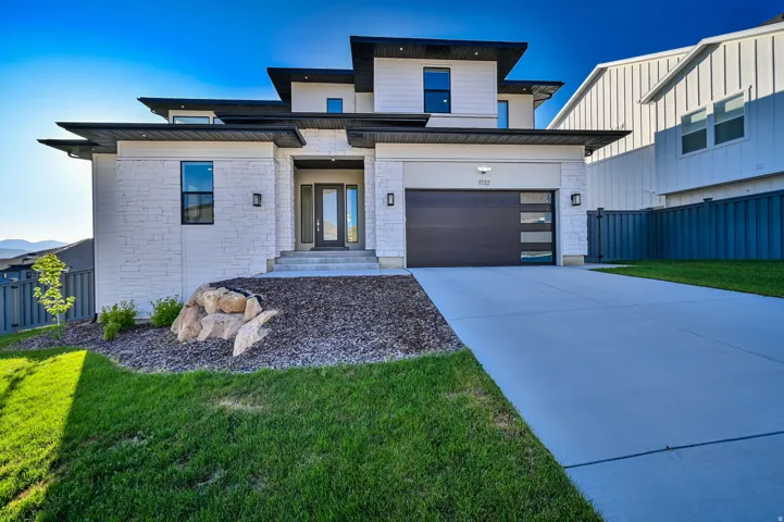 Modern architectural exterior featuring white stacked stone and horizontal siding accents