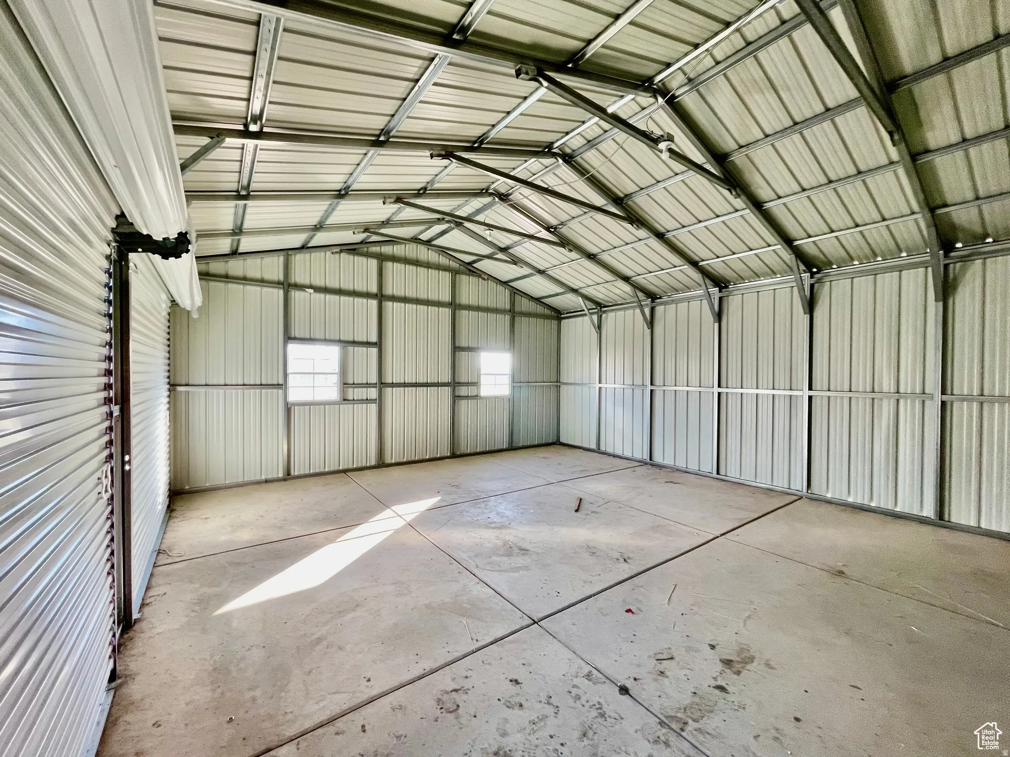 Spacious metal building featuring a vaulted ceiling and concrete flooring