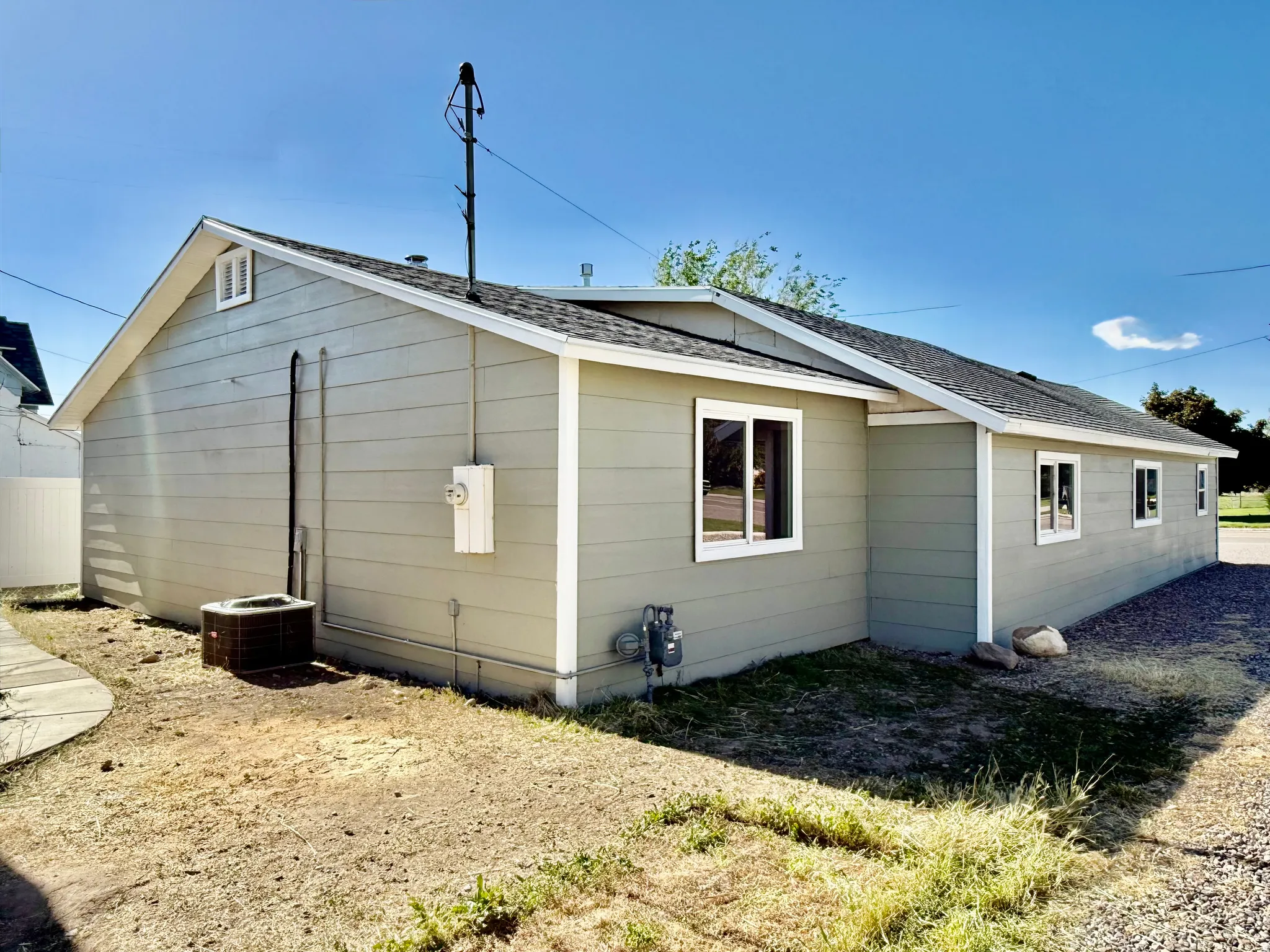 Exterior featuring horizontal siding, white trim, a gabled roofline, and multiple windows