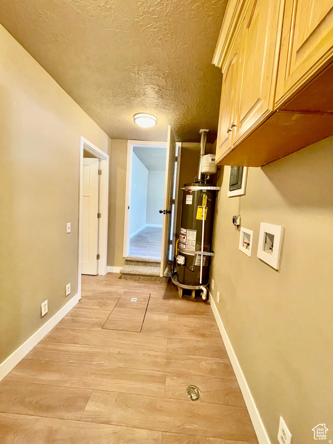 Utility area featuring wood-finish tile flooring and built-in upper cabinetry