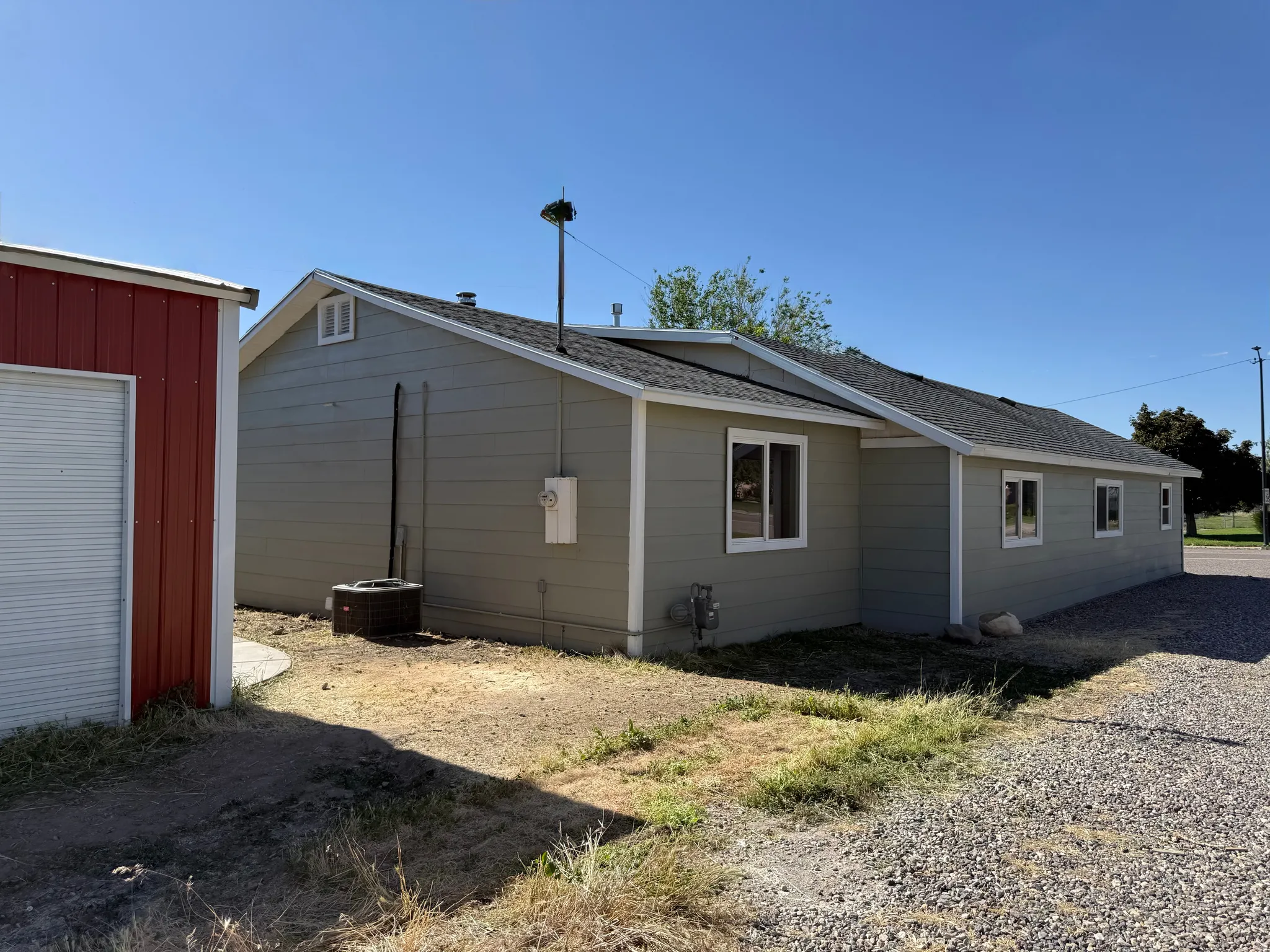 Single-story structure with light gray siding and white trim