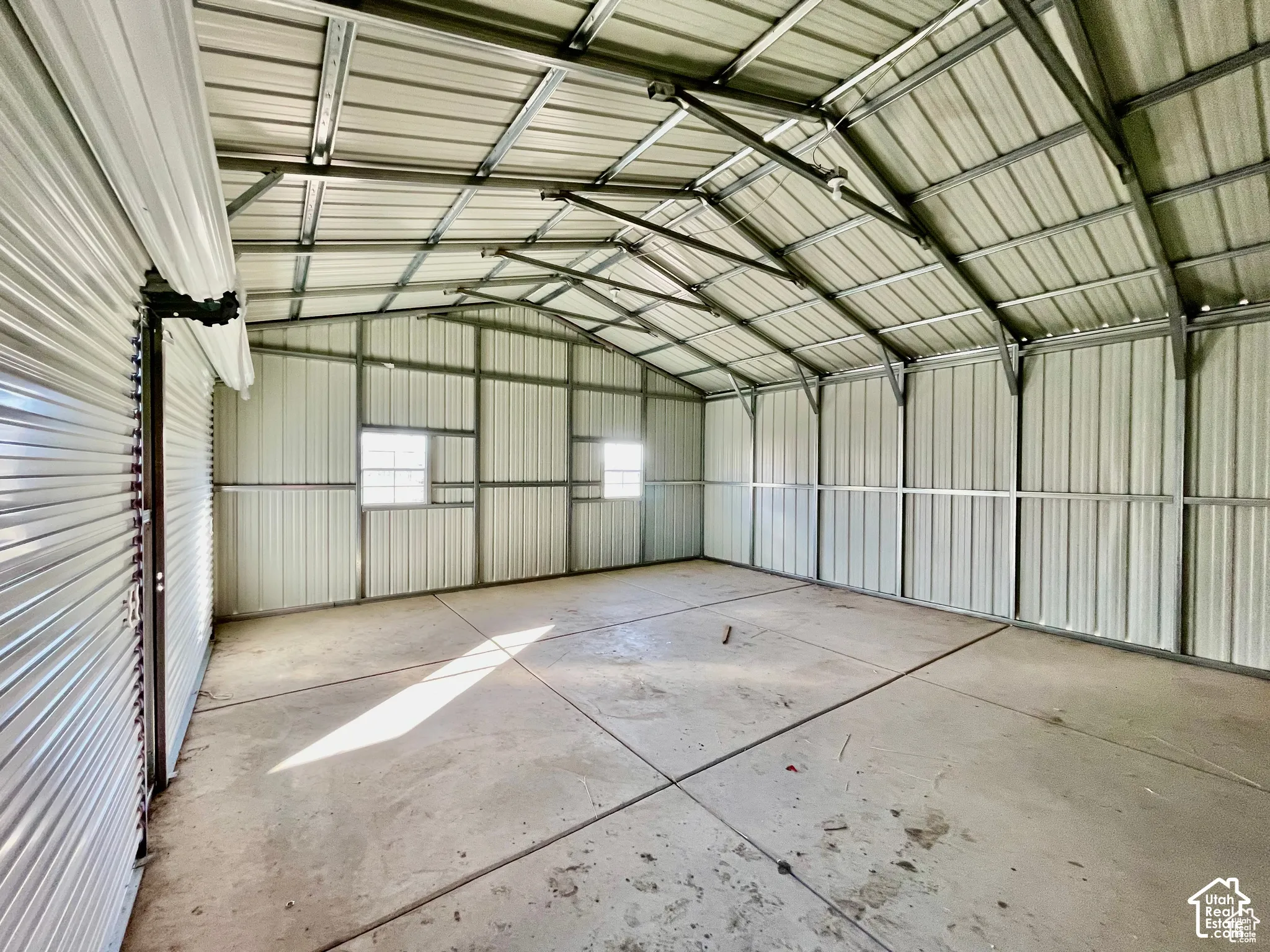 Spacious metal building featuring a vaulted ceiling and concrete flooring