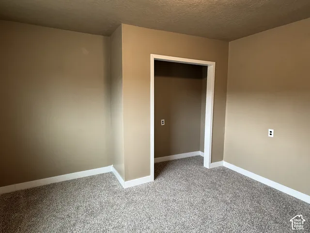 Room featuring neutral-toned walls, white baseboards, and a doorway with white trim