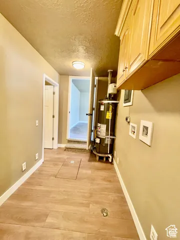 Utility area featuring wood-finish tile flooring and built-in upper cabinetry