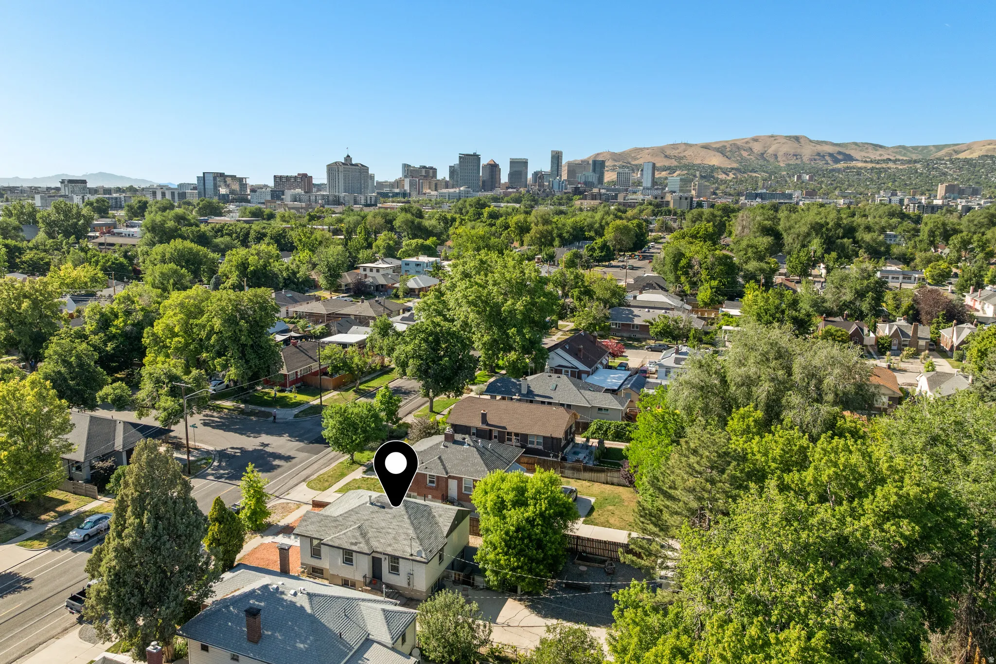 Aerial perspective showcasing a residential neighborhood with a distant cityscape and mountainous terrain
