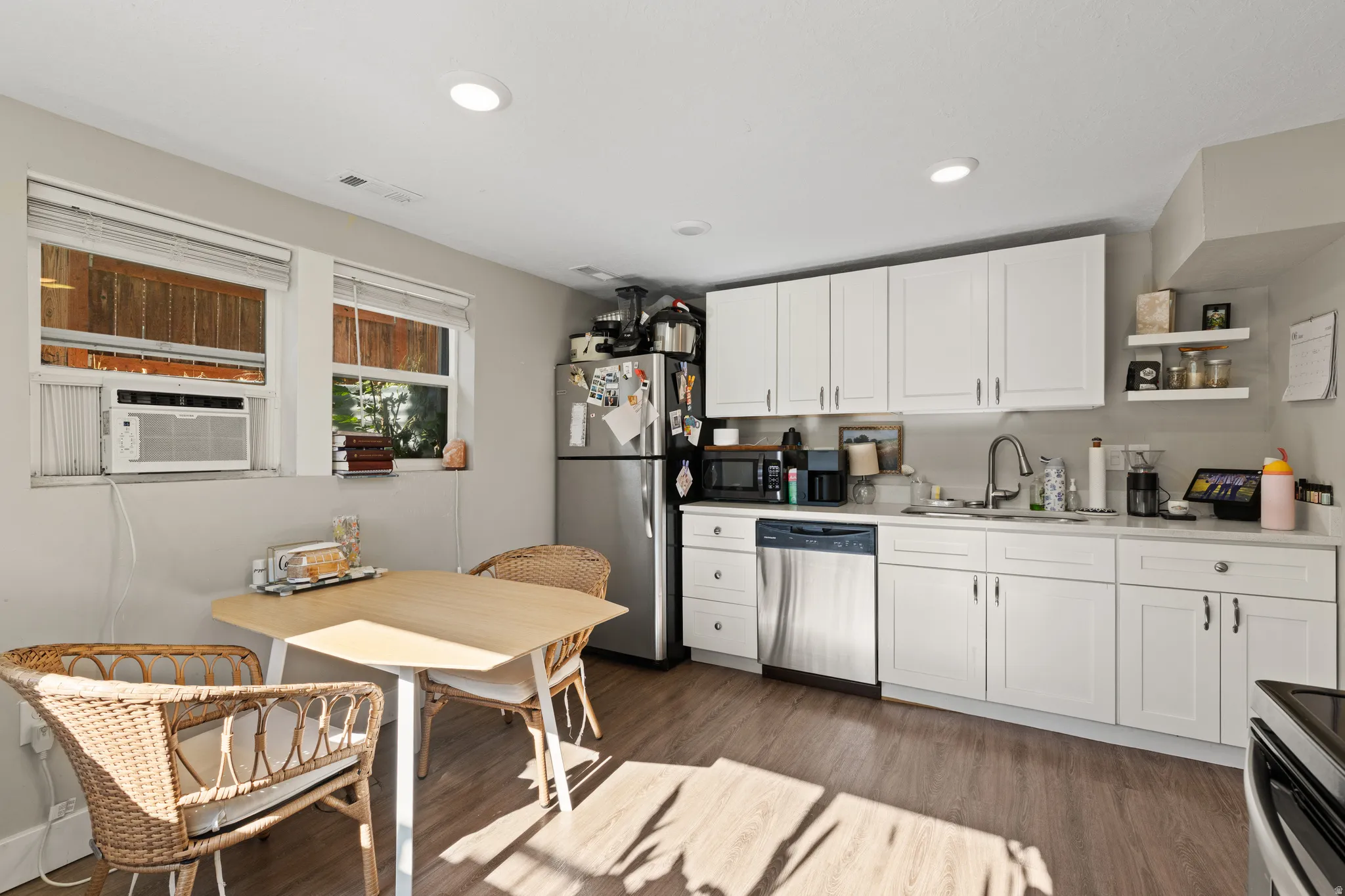 Kitchen featuring white shaker-style cabinetry, stainless steel appliances, and a light-toned countertop