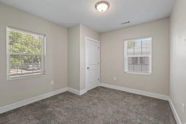 Carpeted room with neutral wall tones and white baseboards