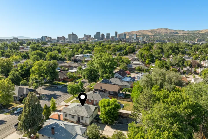 Aerial perspective showcasing a residential neighborhood with a distant cityscape and mountainous terrain