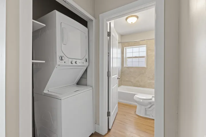 White stackable washer and dryer unit in a dedicated closet