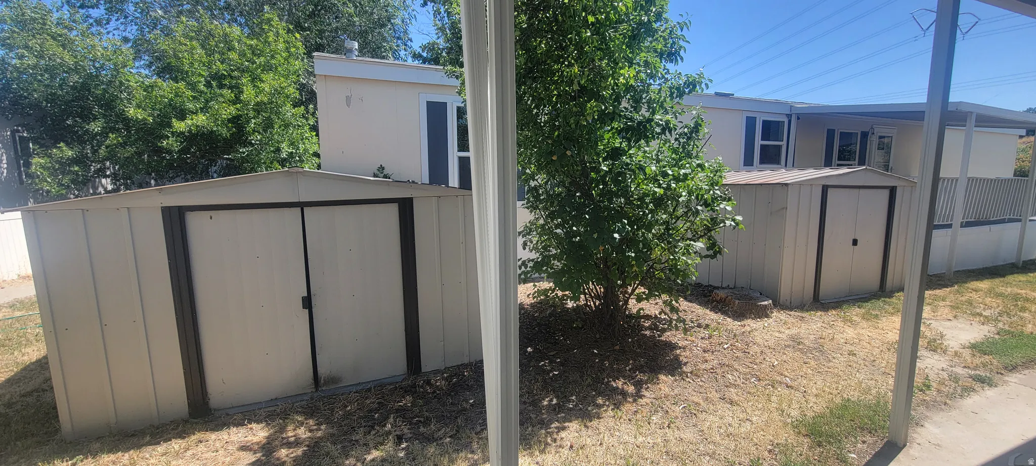 Two detached storage sheds featuring double doors and corrugated metal siding
