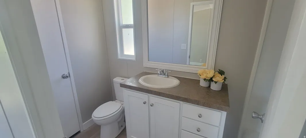 Bathroom featuring a white vanity with built-in storage, an integrated sink, and a framed mirror