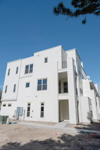 Multi-story residential structure featuring a white brick and horizontal siding exterior