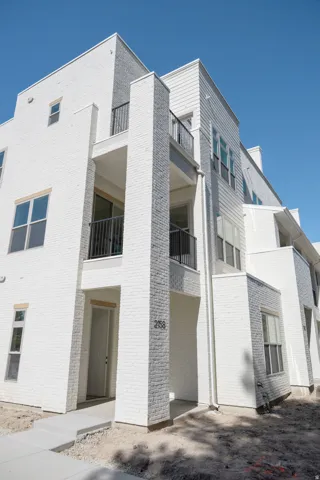 Modern multi-story facade featuring white brick and siding accents
