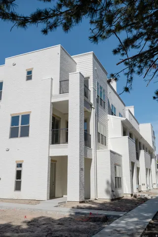 Contemporary multi-story building featuring white brick and siding exterior