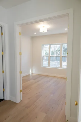 Spacious room featuring light wood-finish flooring, recessed lighting, and a multi-pane window with white trim