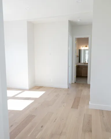 Light wood-finish flooring throughout, featuring a bright neutral color palette