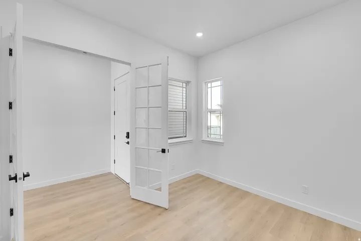 Bright room featuring light wood-finish flooring and recessed ceiling lighting