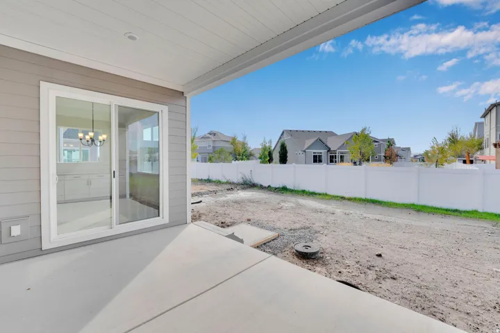 Covered concrete patio with a sliding glass door entry to the interior