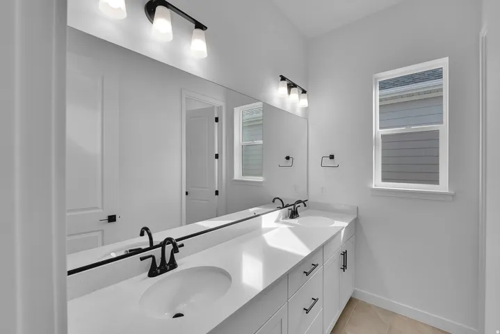 Double vanity featuring undermount sinks, quartz countertops, and matte black fixtures
