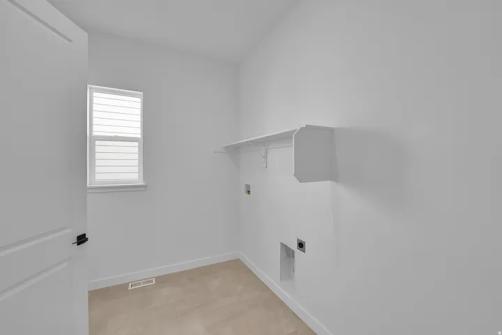 Utility room featuring built-in shelving, tile flooring, a white-framed window with blinds, and white trim