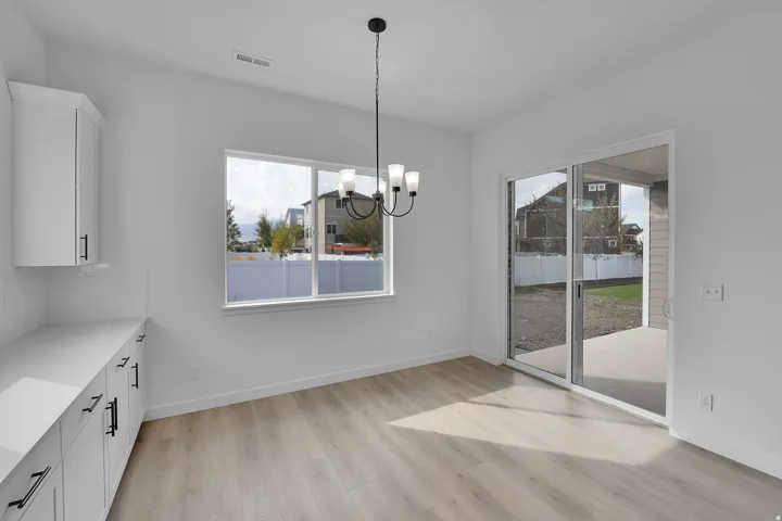 Spacious interior featuring wood-finish flooring and a contemporary chandelier