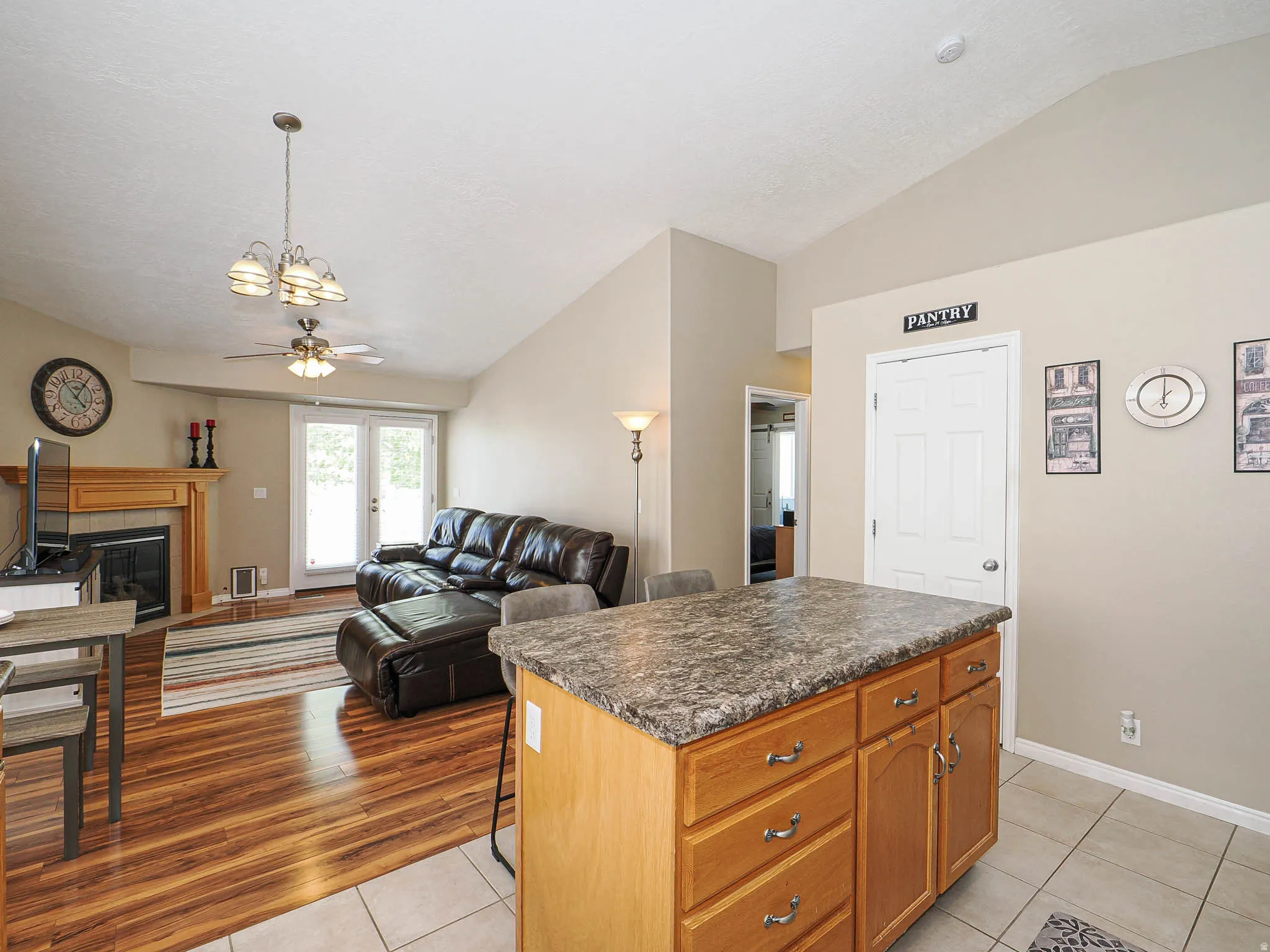 Kitchen island with wood-finish cabinetry, a textured countertop, and tile flooring