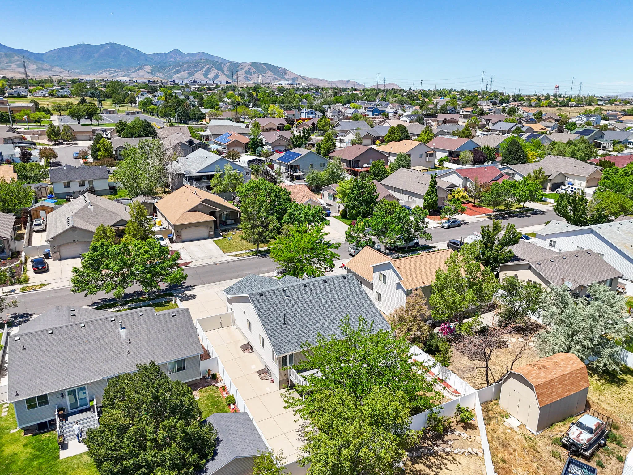 Aerial perspective highlighting the property within a residential neighborhood with surrounding mountains