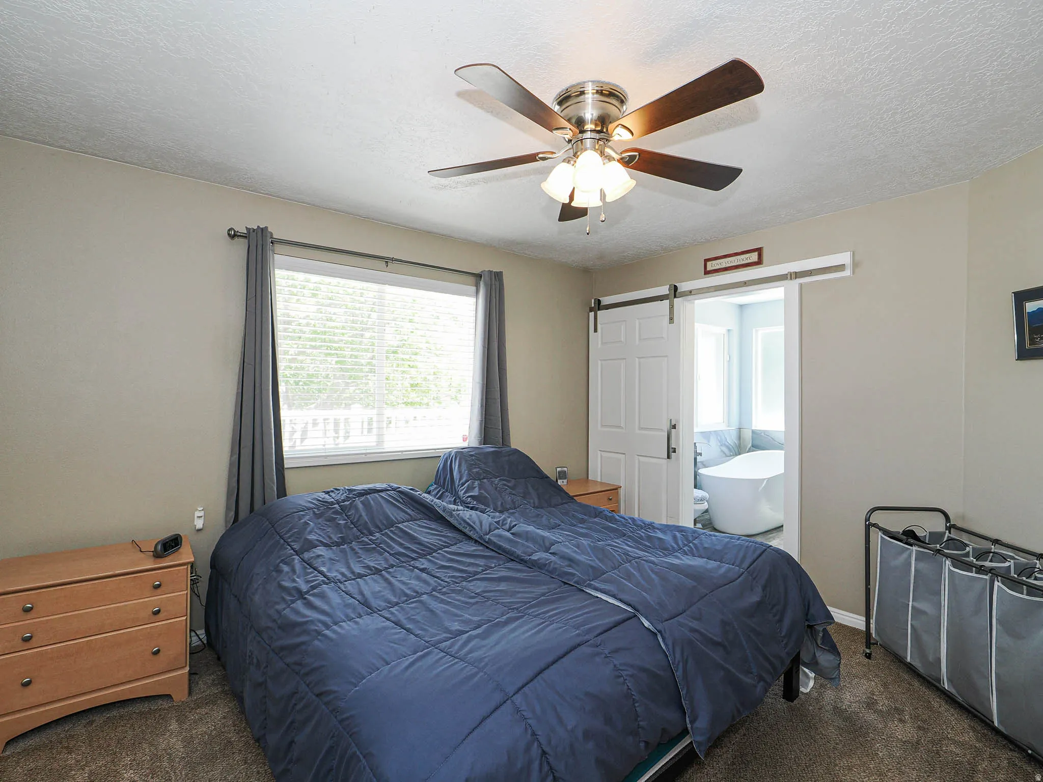Bedroom featuring a ceiling fan with integrated lighting, a window with horizontal blinds, and carpet flooring