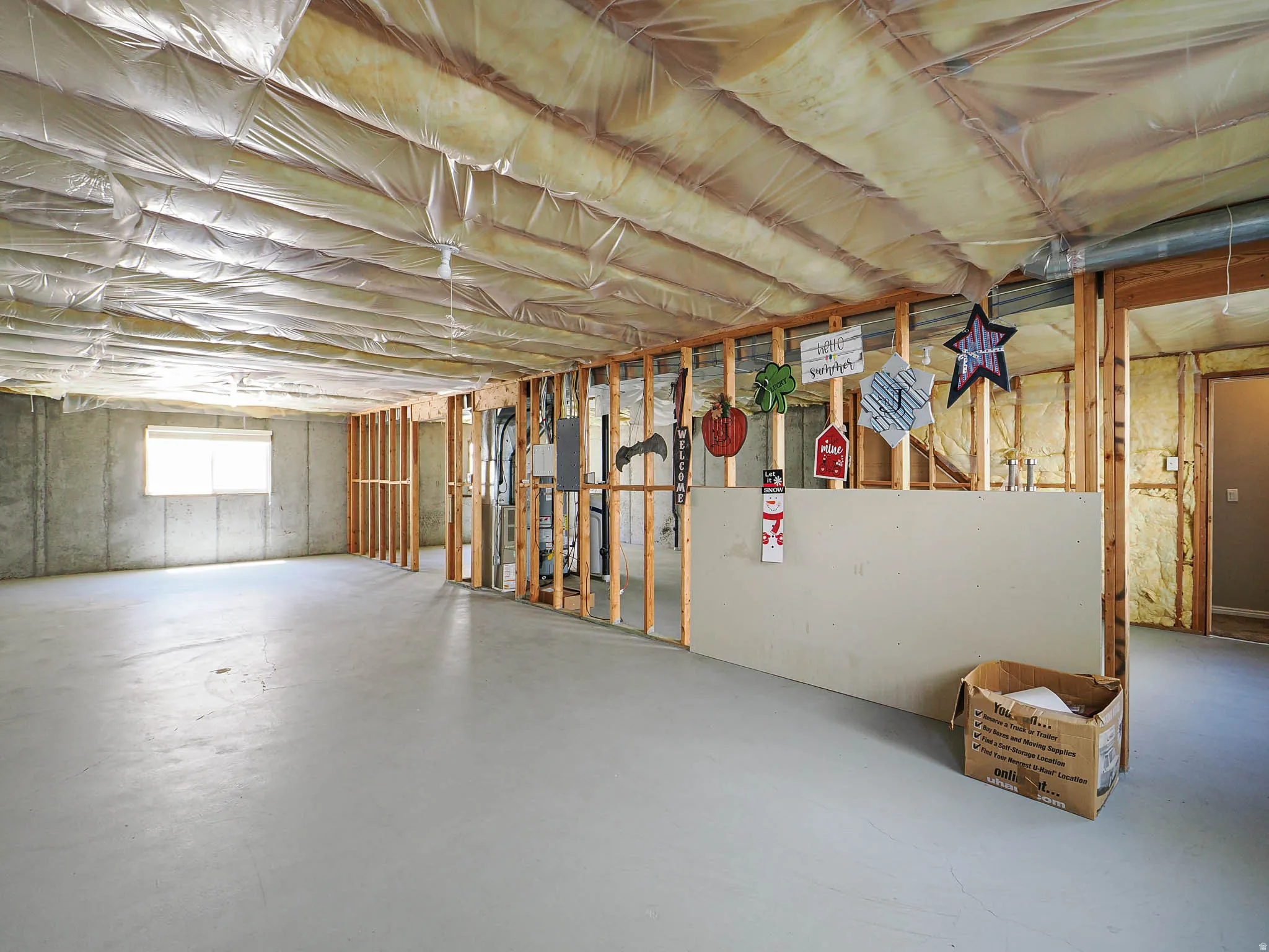 Spacious unfinished basement offering concrete flooring, concrete block walls, exposed wood framing, and a window for natural light