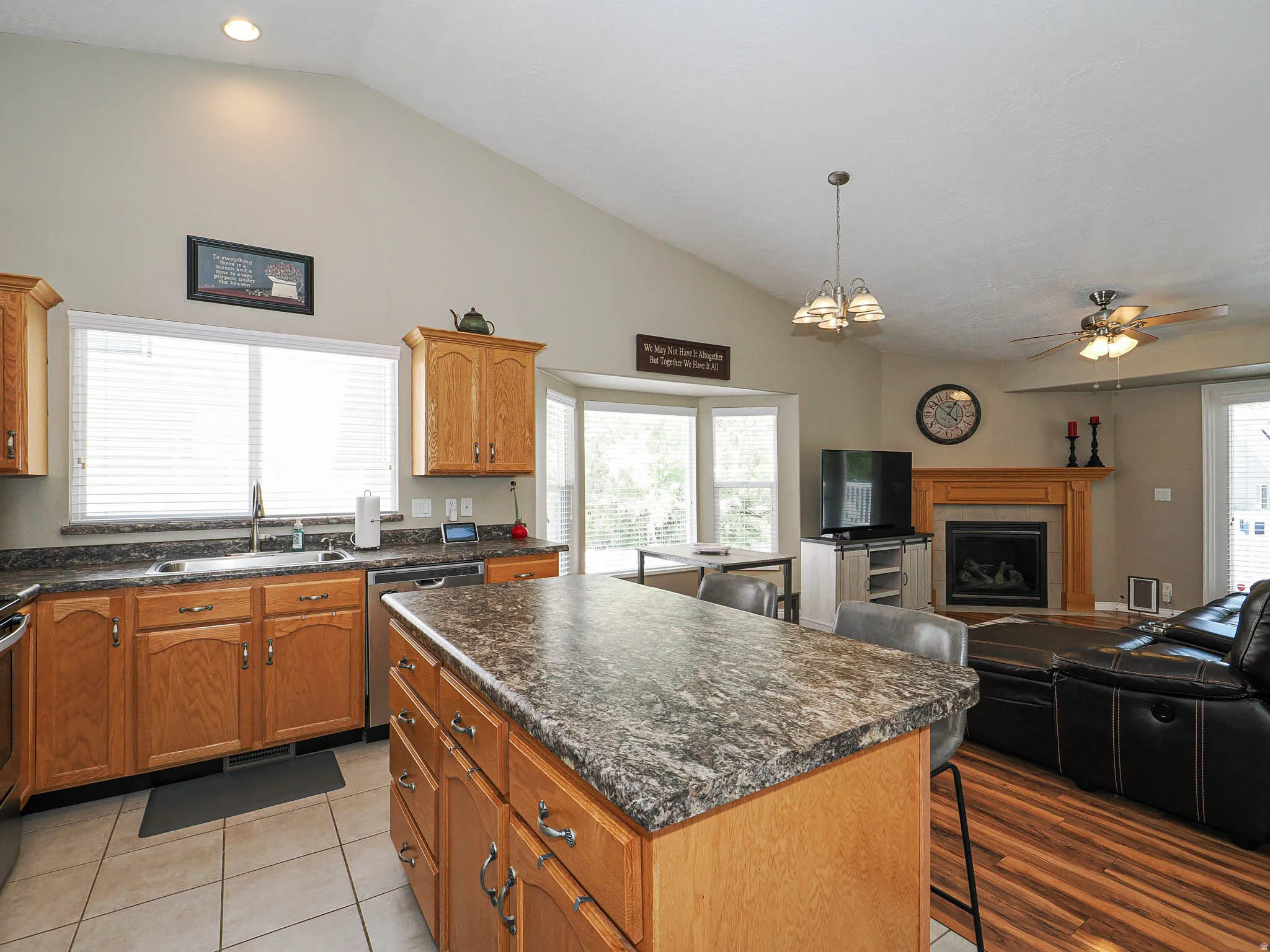 Open-concept kitchen featuring wood cabinetry, a large kitchen island with counter seating, and tiled flooring